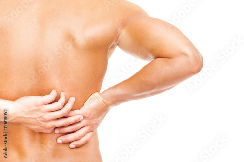 Rear view of a young muscular man holding his back in pain, isol