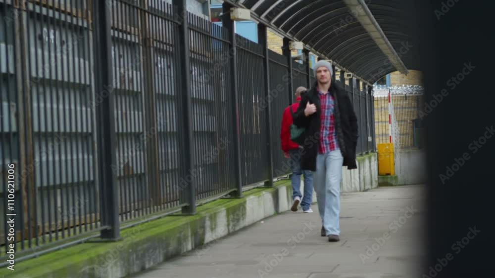 Serious man walking alone, away from railway station. Serious man walking alone, away from railway station.