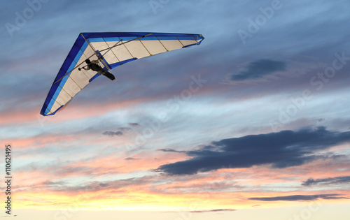 Hanglider - Hanglider Flying over the ocean at sunset