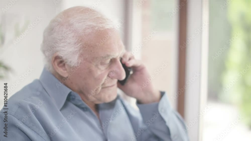  Elderly man in a wheelchair talking on mobile phone 
