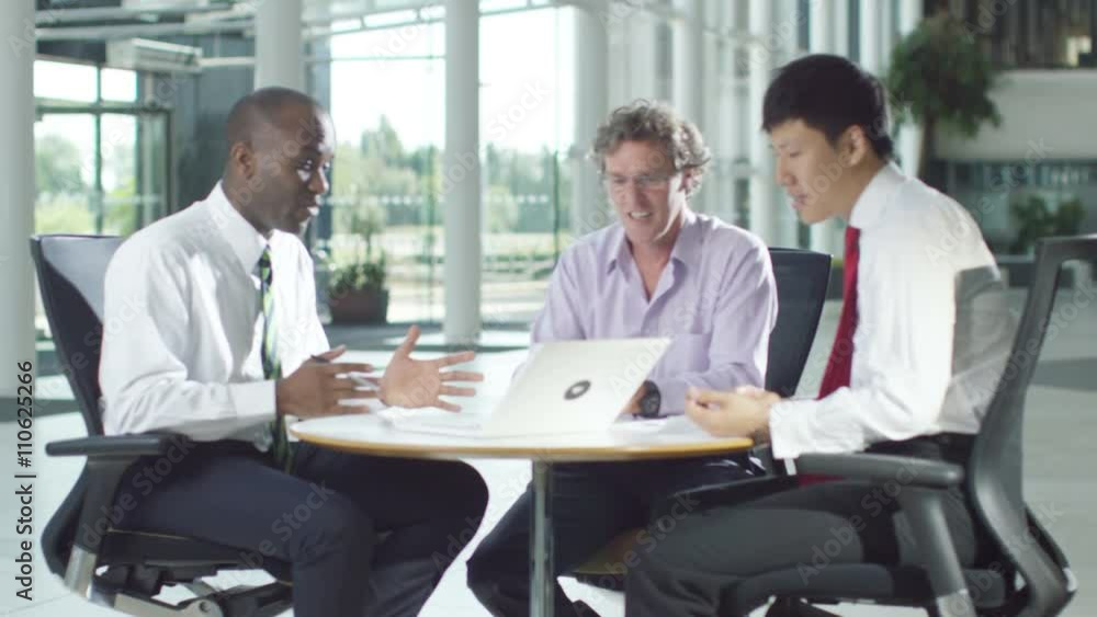 Confident male business group in negotiation meeting shake hands on a deal. Confident male business group in negotiation meeting shake hands on a deal.