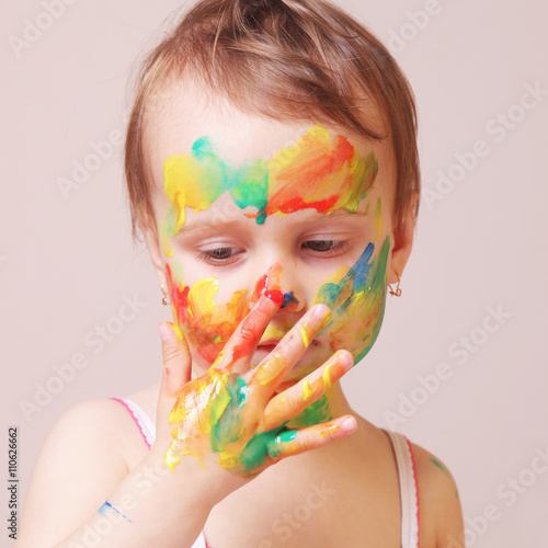 Happy cute little girl with colorful painted hands