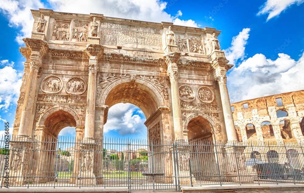 The spectacular Arch of Constantine, located between the Colosseum and the Arch of Titus, built to celebrate the triumph of the emperor Constantine in a sunny day. Rome, Lazio, Italy.