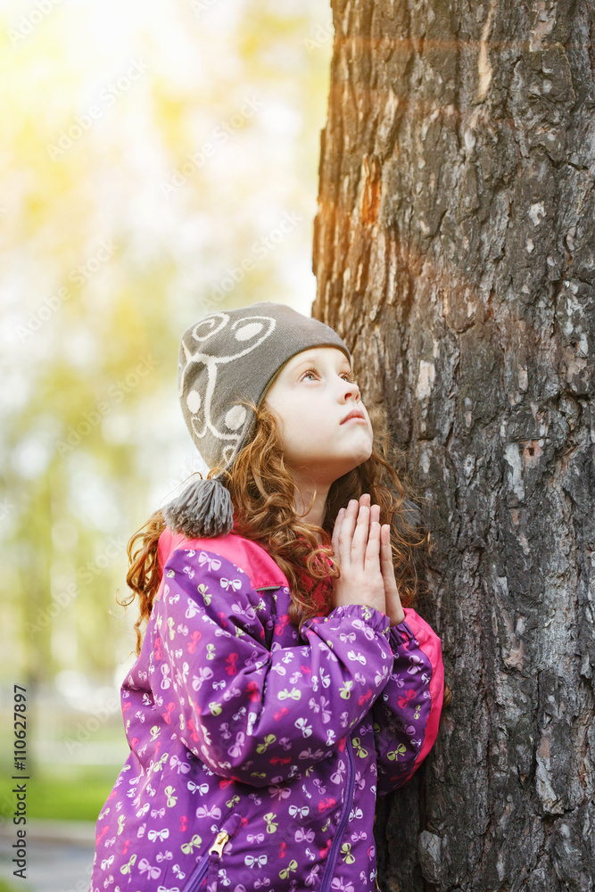 Praying little girl looking up. Happy childhood and world peace Praying little girl looking up. Happy childhood and world peace