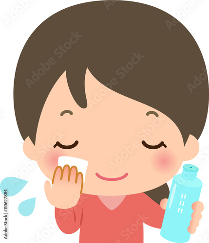 顔に化粧水を塗る若い女性