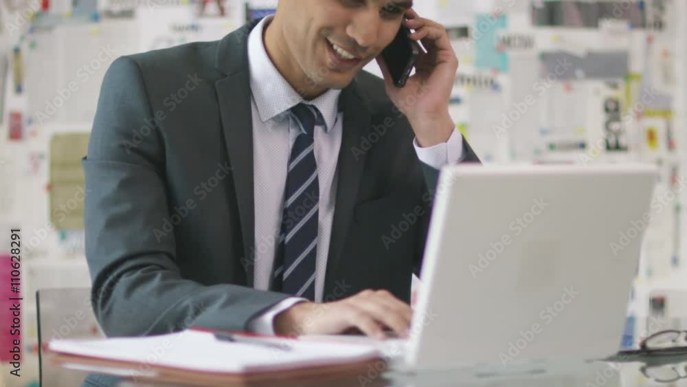 Businessman in office working on laptop computer & making phone call. Businessman in office working on laptop computer & making phone call.