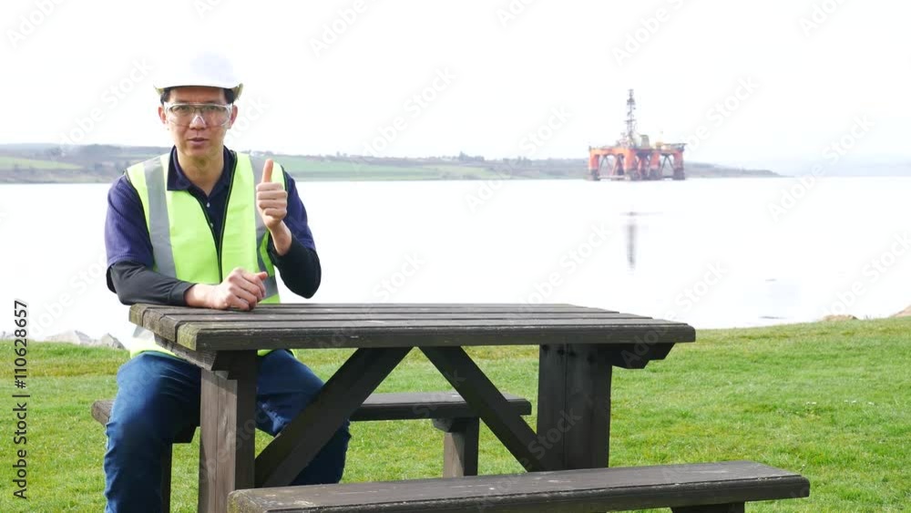 Asian engineer sitting on the desk in front of semi submersible oil rig
Asian engineer sitting on the desk in front of semi submersible oil rig