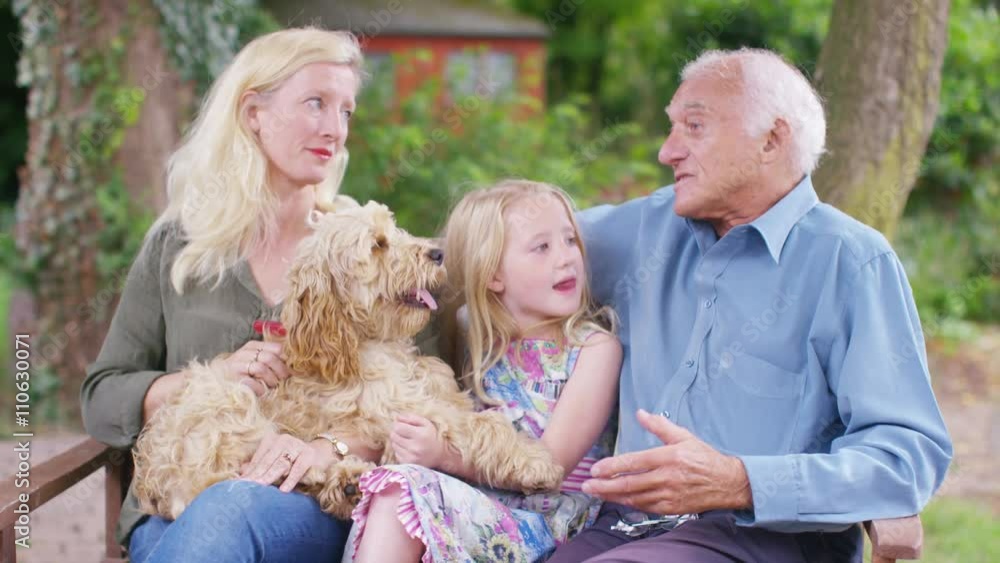 3 generations of a family spending time together in garden with pet dog 3 generations of a family spending time together in garden with pet dog