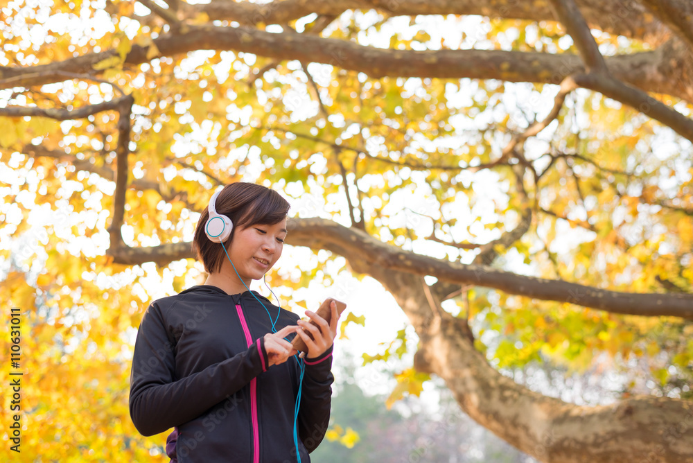 Φωτογραφία スマートフォンで音楽を聞きながらウォーキングする女性