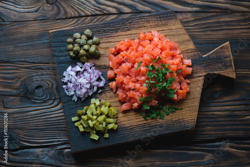 Fotografía Serving board with salmon tartare in a rustic wooden setting