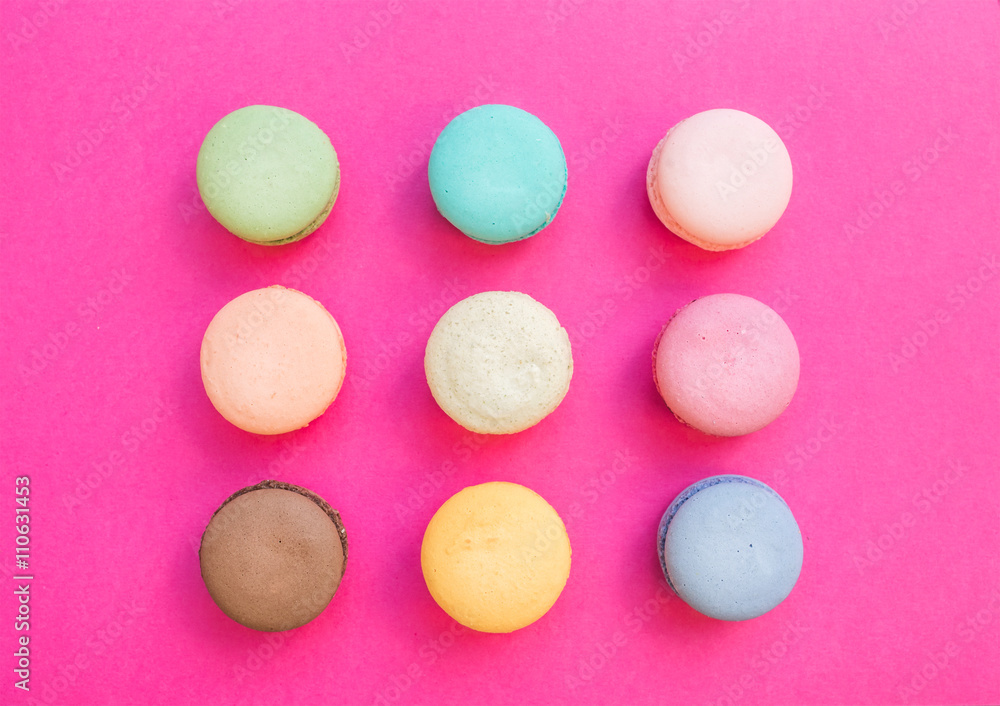Sweet colorful French macaroon biscuits on bright fuchsia pink background Sweet colorful French macaroon biscuits on bright fuchsia pink background