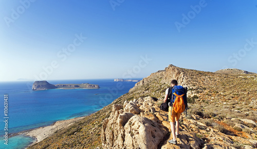 A young man walking in the mountains near the sea