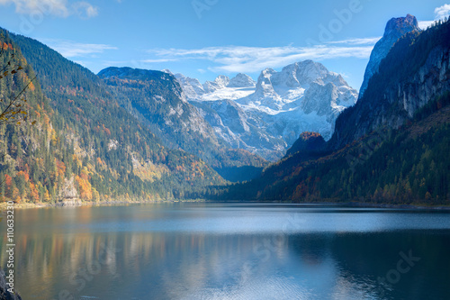 Autumn scenery of Lake Gosausee with snow-capped Dachstein Mountain in the background & beautiful reflections on smooth water, in Gosau, Austria ~ A dramatic scene of unspoiled nature of Alps