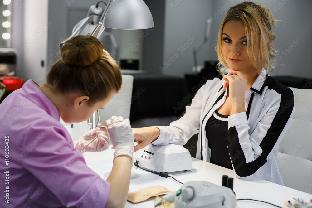 Manicure care procedure, Close-up photo Of Beautician Hand Painting Nails Of Woman In Salon Manicure care procedure, Close-up photo Of Beautician Hand Painting Nails Of Woman In Salon