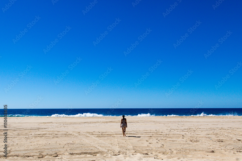 Young woman walking in a empty beach in baja California, Mexico