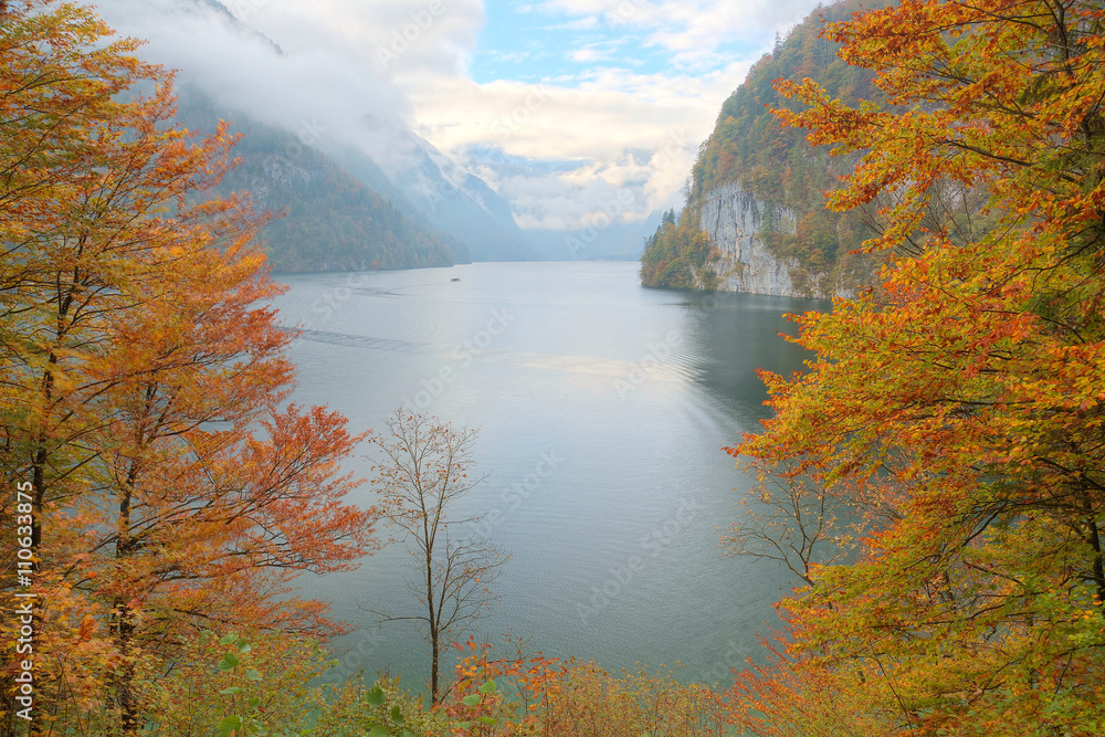 View of Koenigssee ( King's Lake) surrounded by alpine mountains from Malerwinkel viewpoint in colorful autumn season ~ Beautiful scenery of Bavarian countryside in Berchtesgaden Germany
