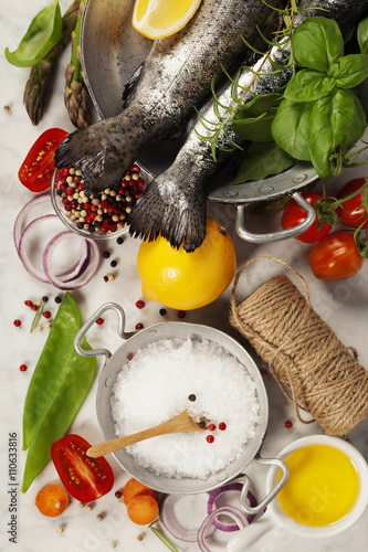 Billede på lærred Raw rainbow trout with vegetables, herbs and spices
