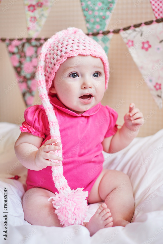 newborn baby girl in pink knitted hat on the bed newborn baby girl in pink knitted hat on the bed