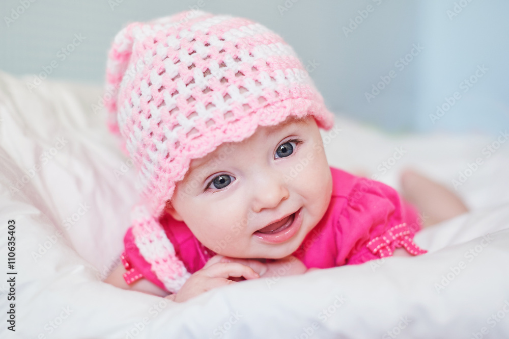newborn baby girl in pink knitted hat on the bed newborn baby girl in pink knitted hat on the bed