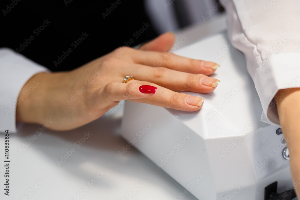 Obraz premium Manicure care procedure, Close-up photo Of Beautician Hand Painting Nails Of Woman In Salon