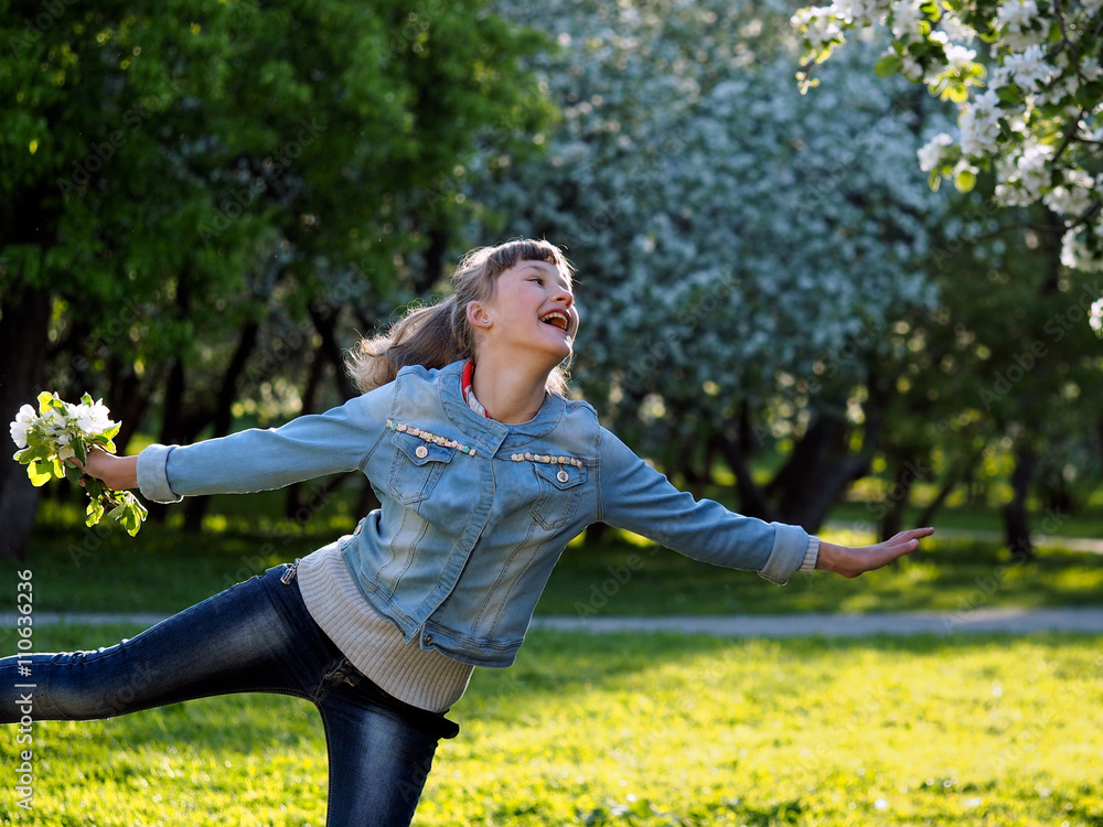 Happy teenage girl in the sunlight. Emotions - happiness, joy. Woman laughing happily. Park dawn. Flowers of apple, apple orchard. Girl dancing, jumping Happy teenage girl in the sunlight. Emotions - happiness, joy. Woman laughing happily. Park dawn. Flowers of apple, apple orchard. Girl dancing, jumping