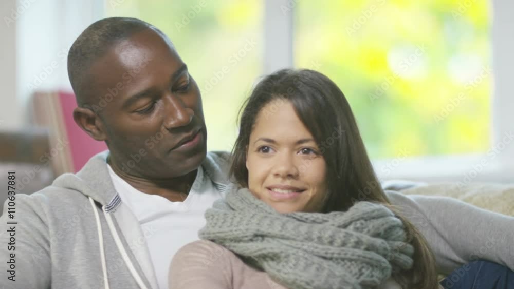 Attractive affectionate couple relaxing at home & watching TV Attractive affectionate couple relaxing at home & watching TV