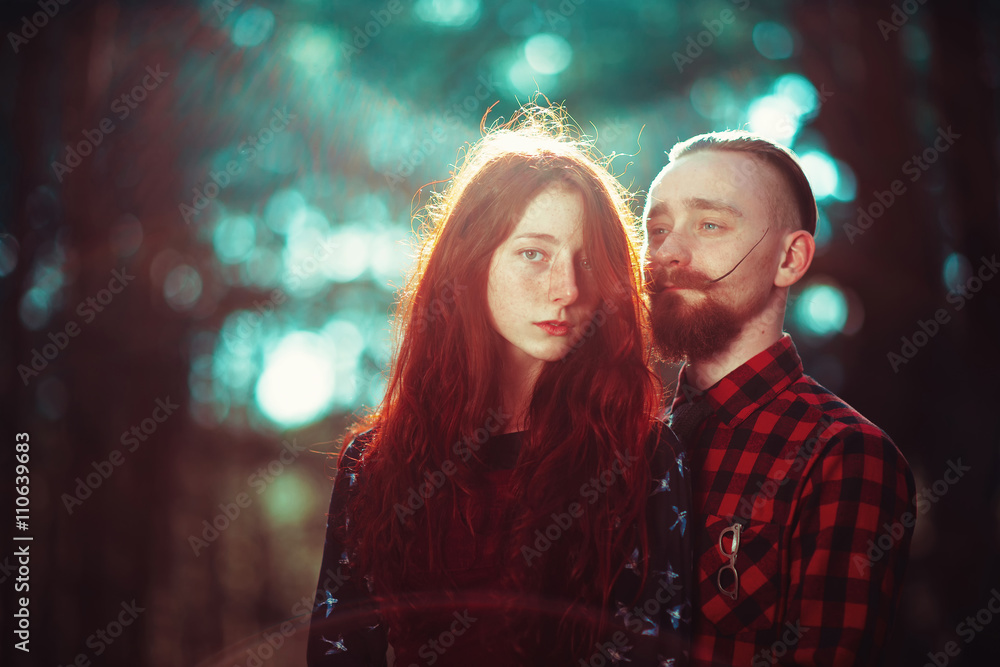The red-haired guy with a beard and curly red-haired girl on the background of fabulous scenery of nature. Beautiful loving couple on a walk in the woods. The red-haired guy with a beard and curly red-haired girl on the background of fabulous scenery of nature. Beautiful loving couple on a walk in the woods.