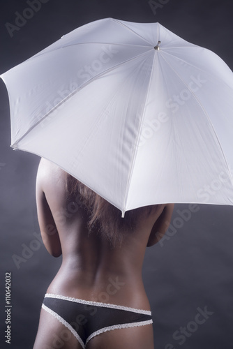 Black woman with umbrella from back