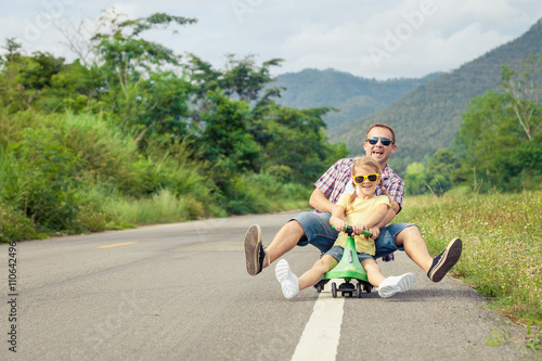 Father and daughter playing  on the road at the day time.