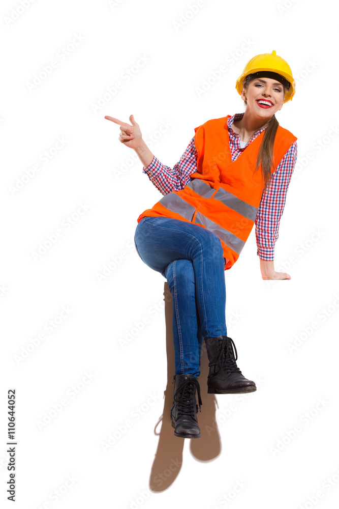 Laughing Female Construction Worker Sitting And Pointing Laughing Female Construction Worker Sitting And Pointing