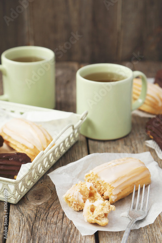 Sweet eclairs on a grey wooden table