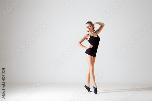 Dancing lady in a black clothes. Contemporary modern dance on a white background isolated. Fitness, stretching model