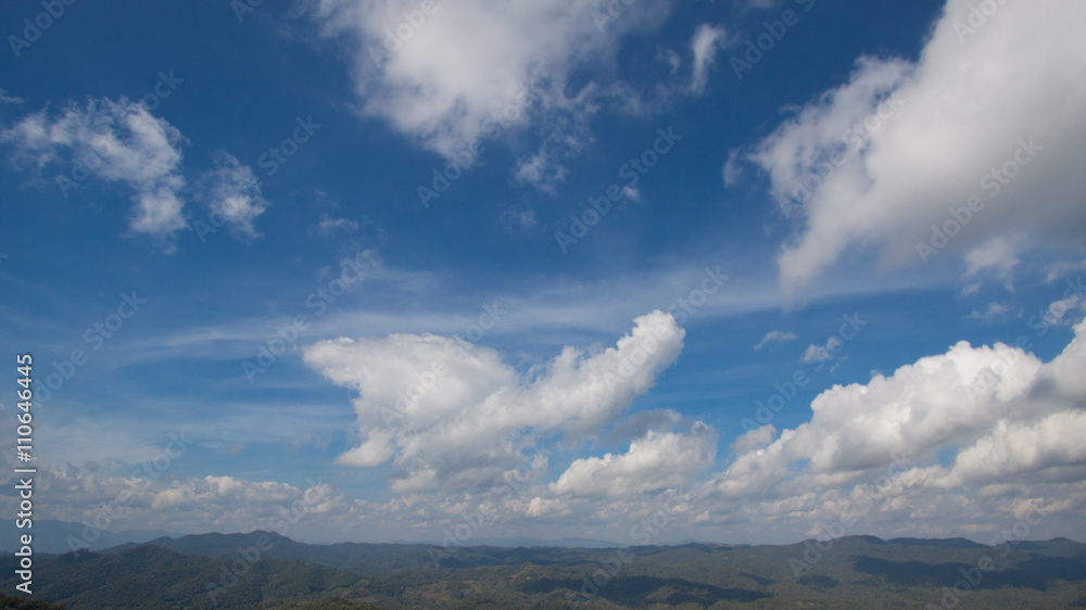 cloudy blue sky with mountain and forest