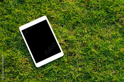 Digital tablet on the green grass