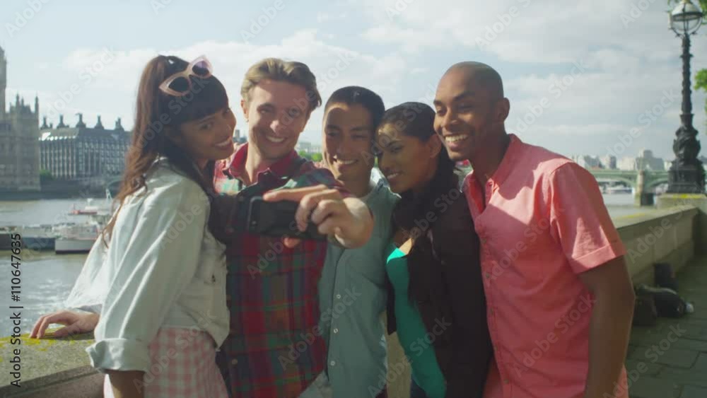 Happy mixed ethnicity friends outdoors in the city pose to take a selfie Happy mixed ethnicity friends outdoors in the city pose to take a selfie