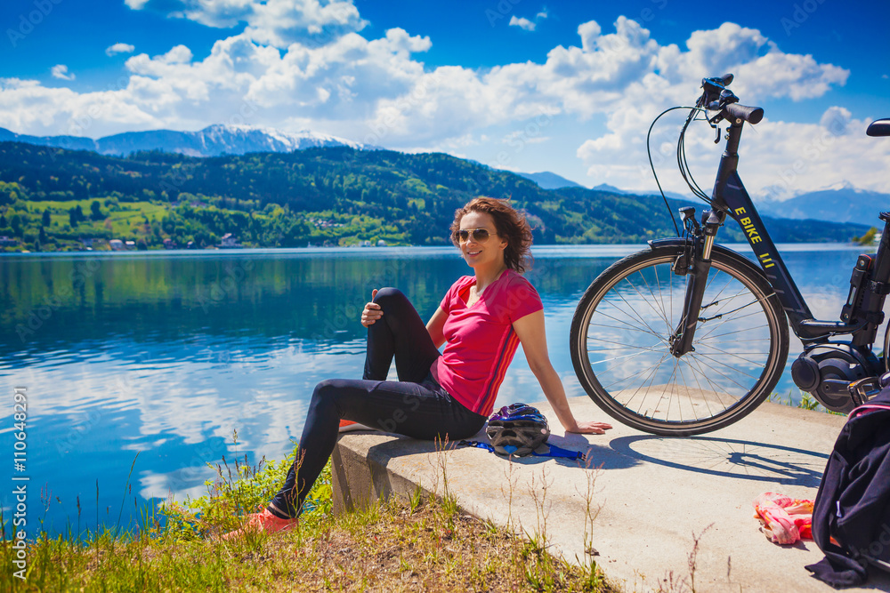 Fototapeta premium woman with e-bike enjoying view over lake-lake and bike 04