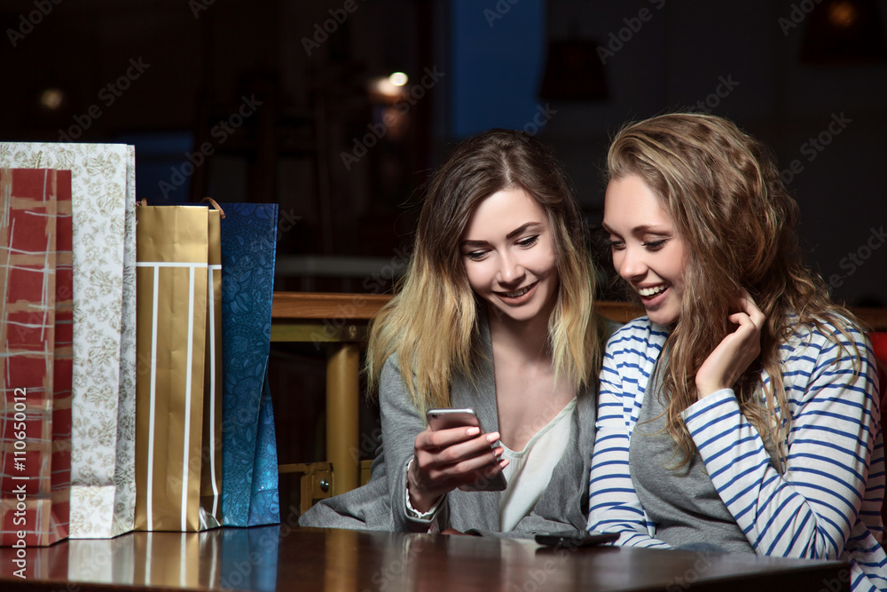 Beautiful girls sitting at a table in a cafe and looking at mobile phone. Fashion Shopping two ladies Portrait. Beauty Woman with Shopping Bags in Shopping Mall. Shopper.
Beautiful girls sitting at a table in a cafe and looking at mobile phone. Fashion Shopping two ladies Portrait. Beauty Woman with Shopping Bags in Shopping Mall. Shopper.