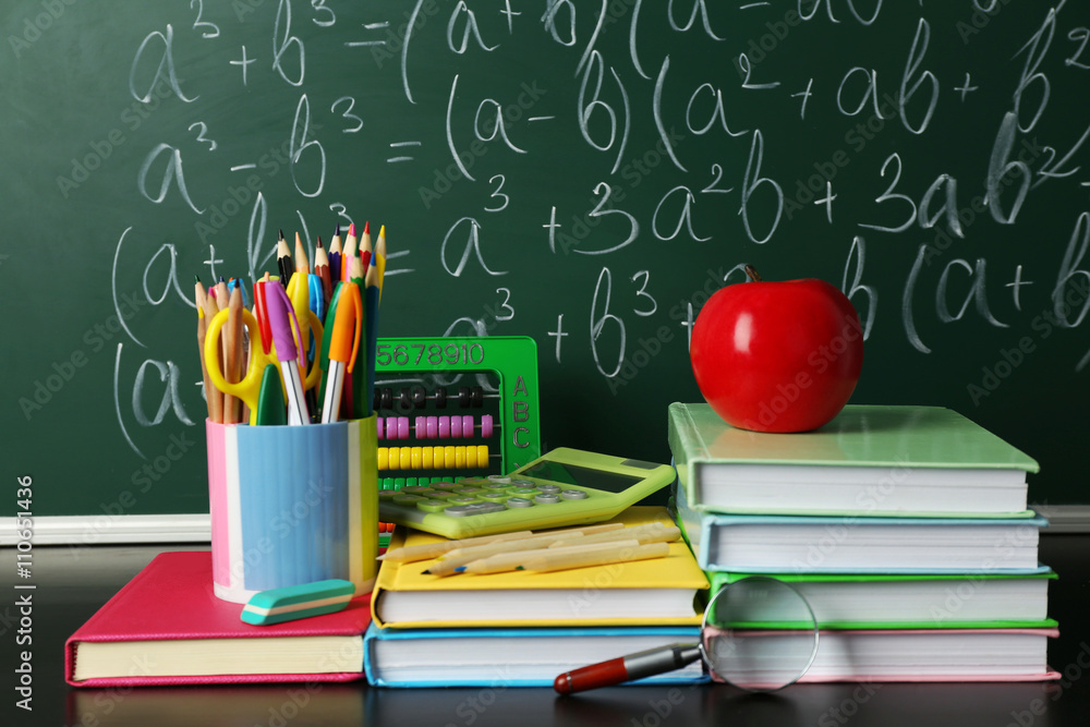 School books on desk near chalkboard School books on desk near chalkboard