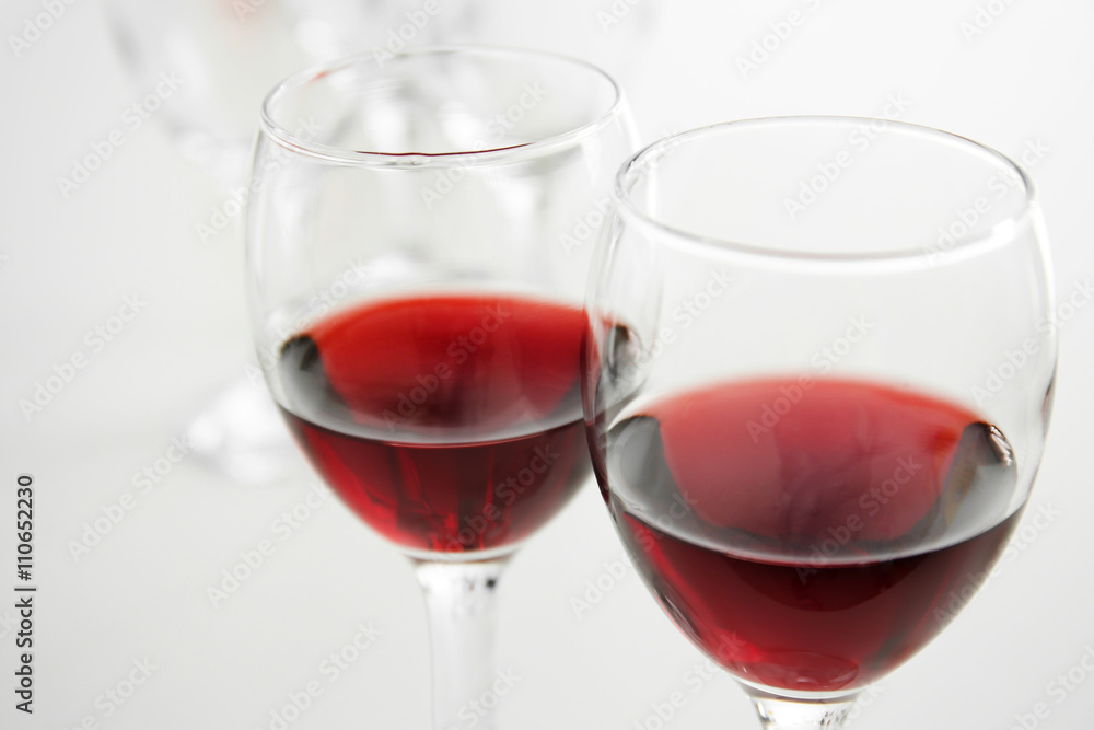 Glasses of red wine on white table closeup Glasses of red wine on white table closeup