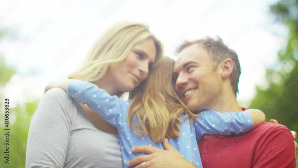 Happy & affectionate parents with young daughter spending time together outdo Happy & affectionate parents with young daughter spending time together outdo