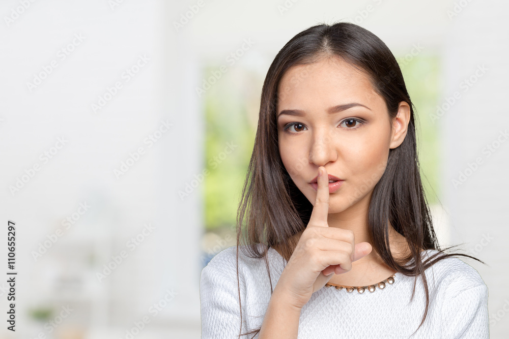 Portrait of attractive teenage girl with finger on lips Portrait of attractive teenage girl with finger on lips