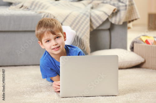 Little boy using laptop on ...