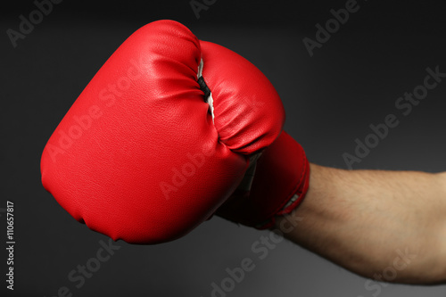 Male hand in boxing glove on grey background © Africa Studio