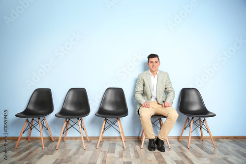 Young man in suit sitting o...