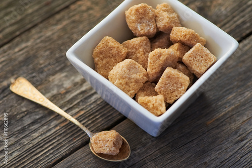 Fotografie brown cane sugar on old wooden background