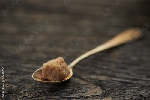 Fotografie brown cane sugar on old wooden background