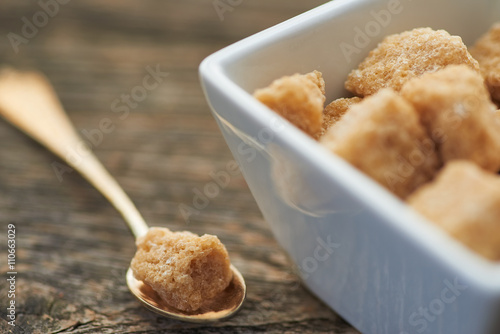 Фотография brown cane sugar on old wooden background