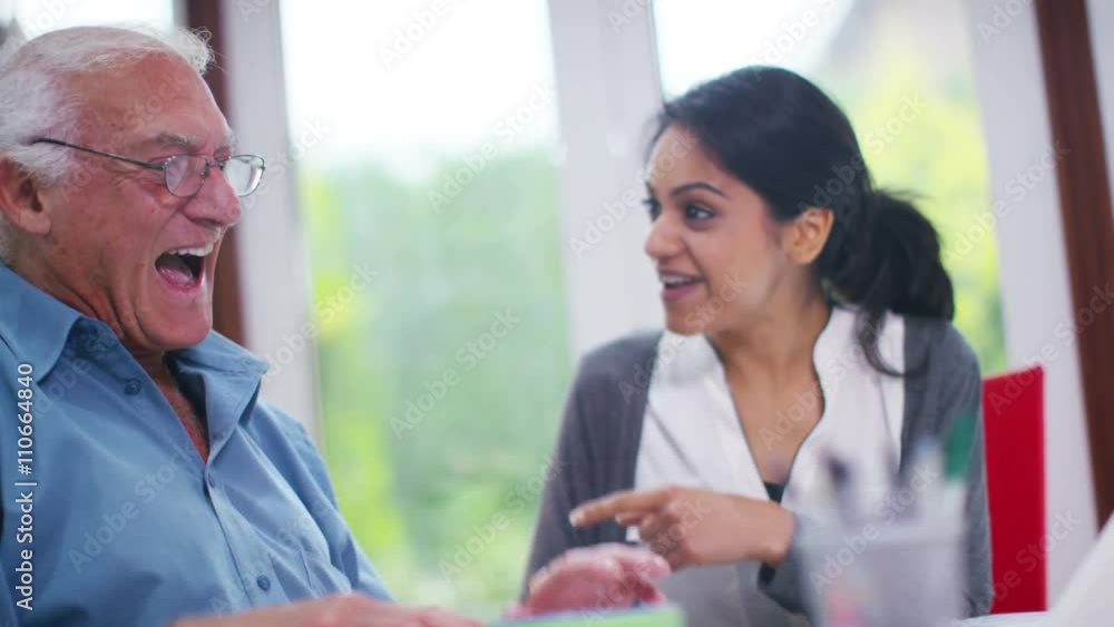 Cheerful home support worker showing elderly man how to use a computer Cheerful home support worker showing elderly man how to use a computer