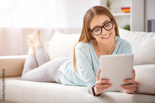 Cheerful woman lying on the couch  