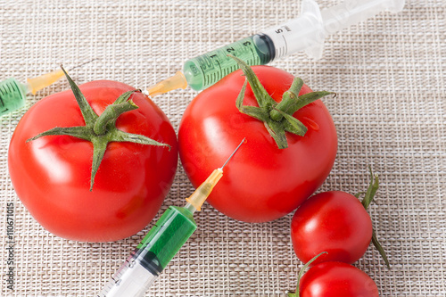 Foto Injection into red tomato - Concept for Genetically modified fruit and syringe w